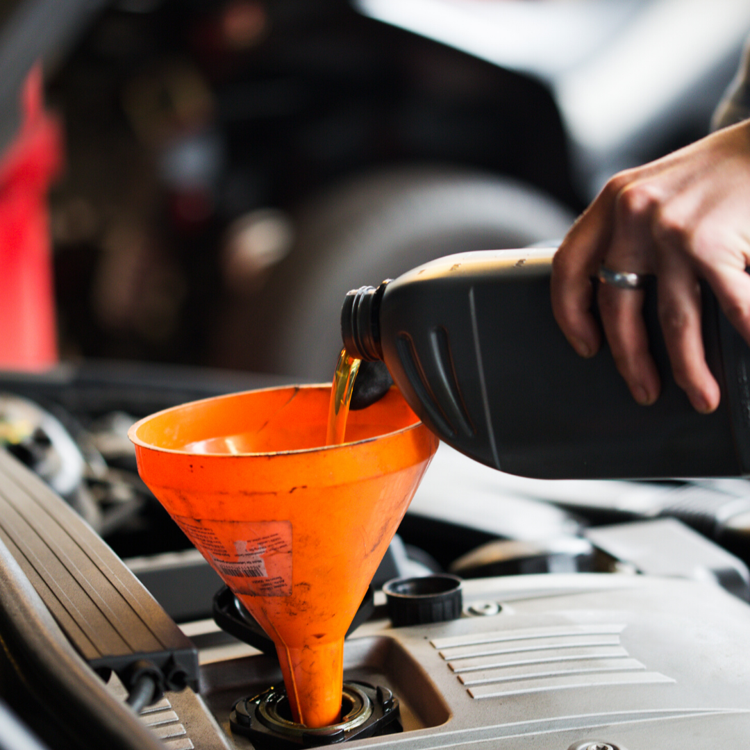 auto care plus service technician pouring fresh oil into a funnel