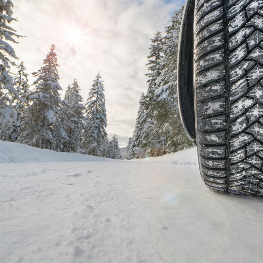 car driving through snow with snow tires, resulting in tire treads being free of snow